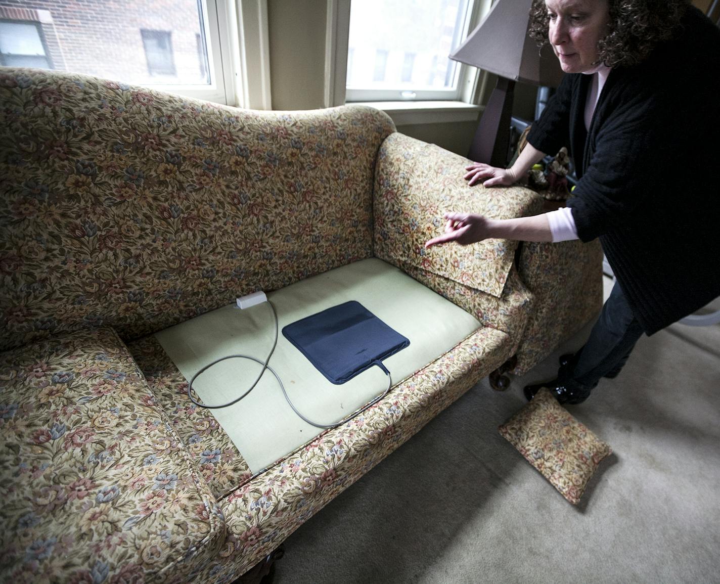 Sally Evans points out the motion sensors in place under couch cushions at the condo she shares with her mother Wilma Evans in St. Paul December 15, 2015. Wilma has dementia, and when there is movement sensed, a recorded message rings to Sally's phone. (Courtney Perry/Special to the Star Tribune)