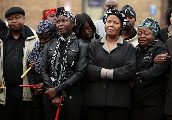 FILE -- Victoria Gbojueh, second from right, mourned with family and friends during a vigil for Gbojueh's sister Beatrice Wilson and Wilson's grandson
