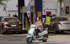 FILE - In this Nov. 4, 2016 file photo, a woman rides her motorbike as she leaves a gasoline station in Cairo, Egypt. Egypt raised the prices of fuel 