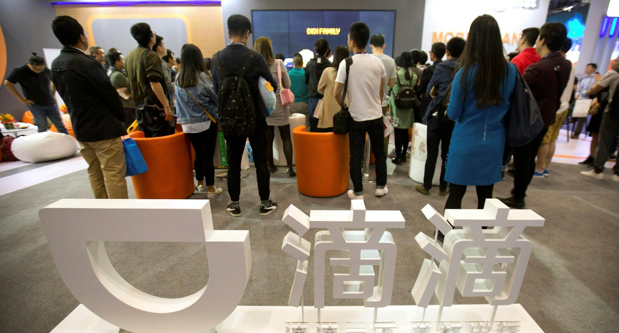 Visitors look at a display booth for Chinese ride-hailing service Didi Chuxing at the Global Mobile Internet Conference (GMIC) in Beijing, Thursday, April 27, 2017. (AP Photo/Mark Schiefelbein) ORG XMIT: XMASOTK101