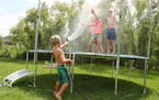 Rusty Golaski, center, 5, sprayed his siblings with a hose as they spent the afternoon playing with their friends on the family's trampoline, despite 