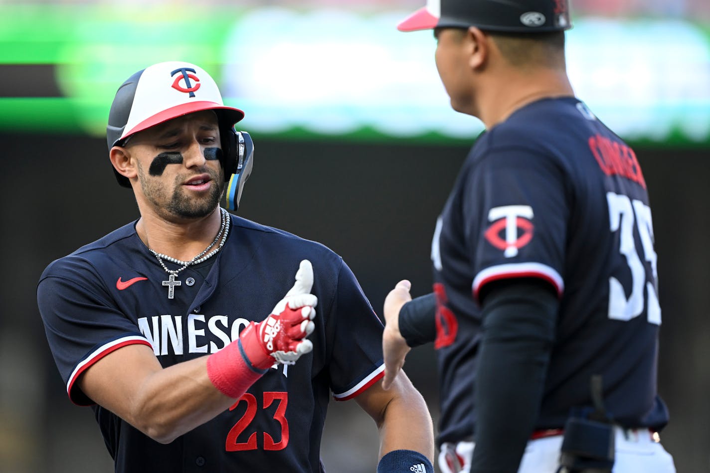 Minnesota Twins third baseman Royce Lewis (23) high fives first base/catching coach Hank Conger (35) after Lewis singled in the bottom of the fourth inning against the Boston Red Sox Tuesday, June 20, 2023, at Target Field in Minneapolis, Minn. ] AARON LAVINSKY • aaron.lavinsky@startribune.com