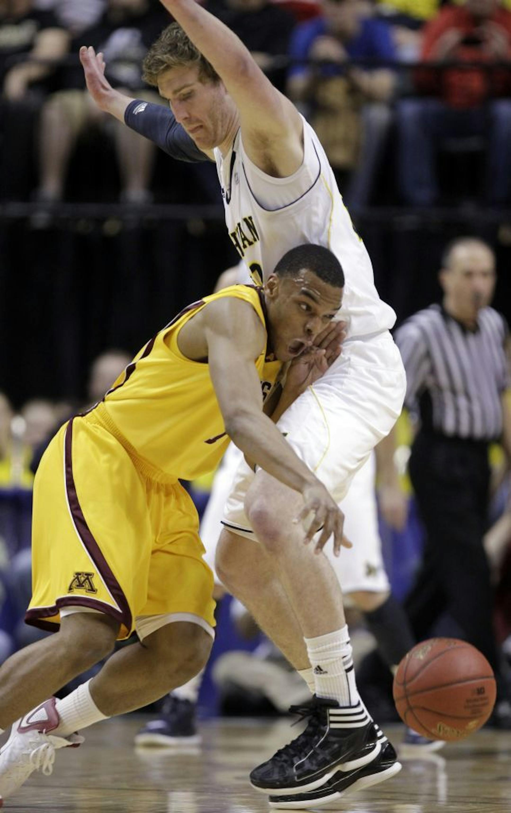 Minnesota guard Andre Hollins, left, drives around Michigan forward Evan Smotrycz in the first half of an NCAA college basketball game in the second round of the Big Ten Conference men's tournament in Indianapolis, Friday, March 9, 2012.