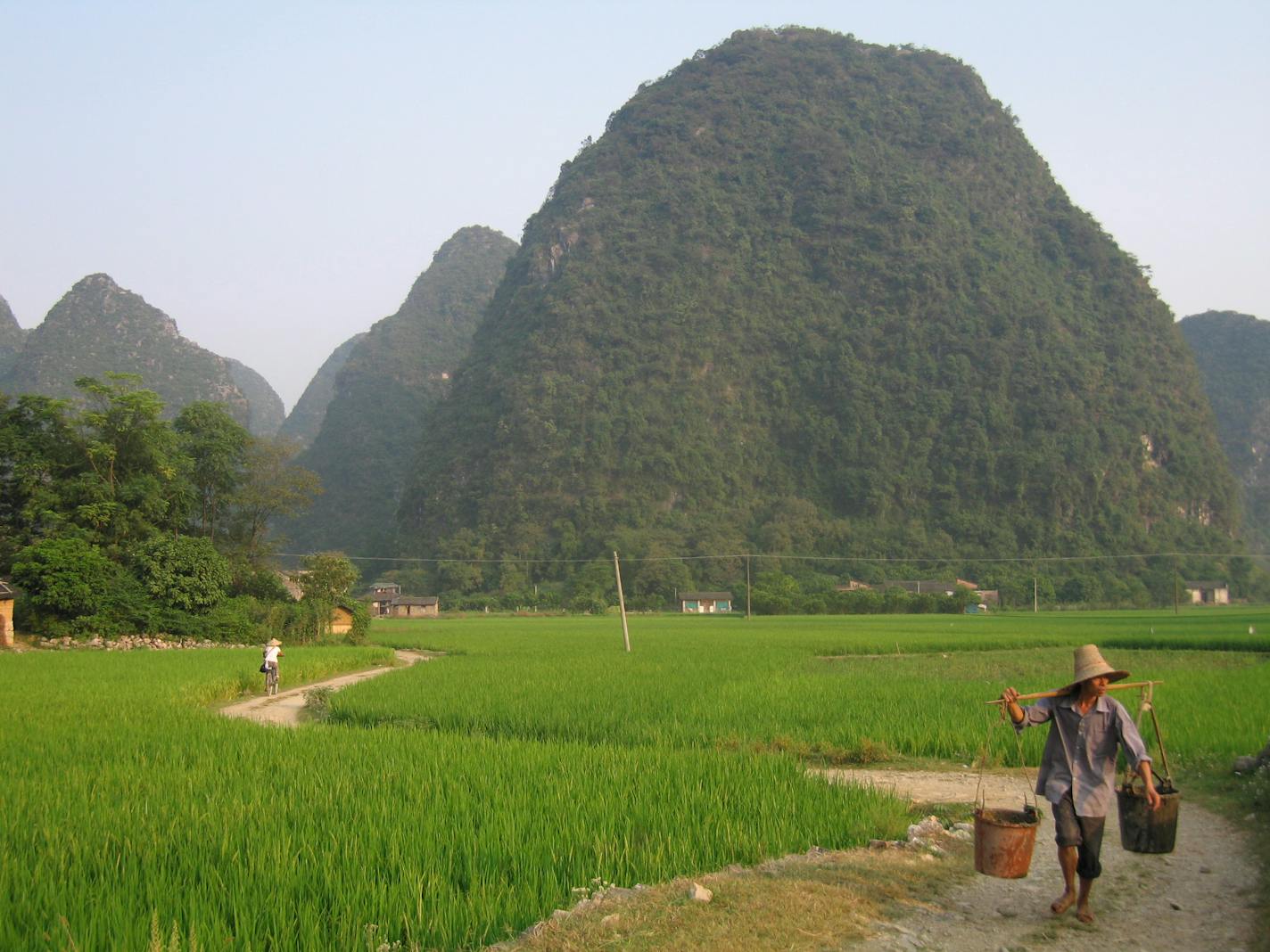 Timing: Henri Cartier-Bresson coined the term "the decisive moment" to describe that instant when a scene is transformed by a movement, a gesture, a glance. There are many qualities worth mentioning in Kelsey Dickens' photo of farm fields in a village near the Yangtze River in China. The image is thoughtfully composed and very balanced, but the timing makes it pop. She chose precisely the right moment to push the shutter release, with the biker going one way and the glance of the worker the othe