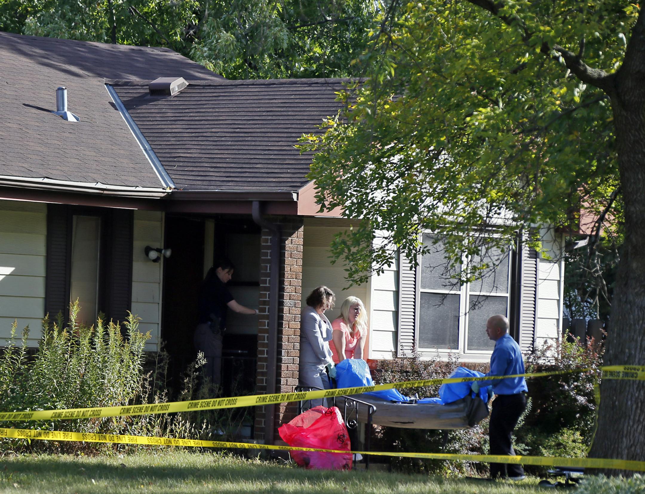 The body of one of the victims was removed from a Brooklyn Center home Monday morning. Reports indicated a man and his adult son were shot dead and the mohter wounded. [ Jerry Holt, Star Tribune, Brooklyn Center, MN 9/23/2013