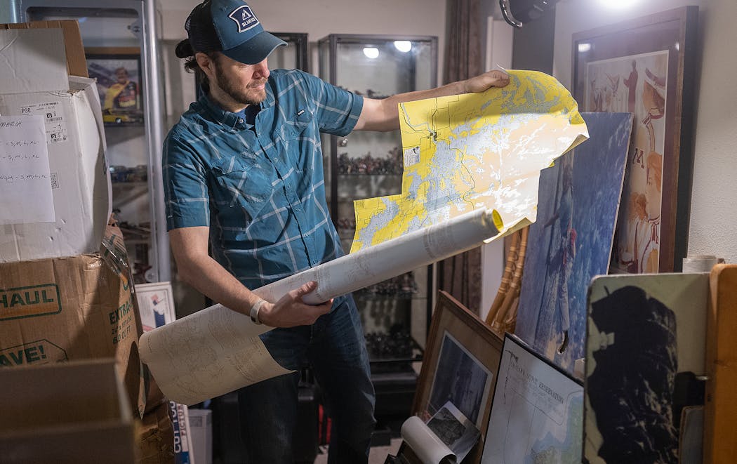 Steve Schreader sifts through memorabilia from Midwest Mountaineering on Friday that he has stored in his basement in St. Paul.