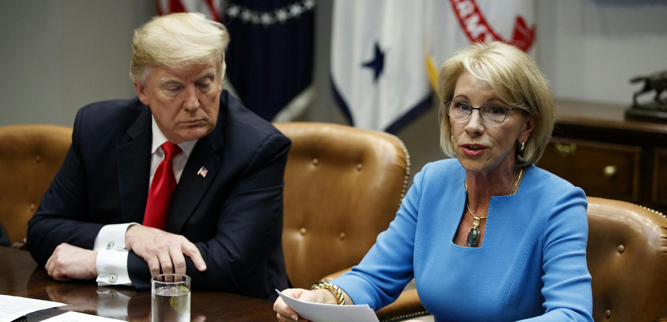 President Donald Trump listens as Secretary of Education Betsy DeVos speaks during a roundtable discussion on the Federal Commission on School Safety report, in the Roosevelt Room of the White House, Tuesday, Dec. 18, 2018, in Washington. (AP Photo/Evan Vucci)