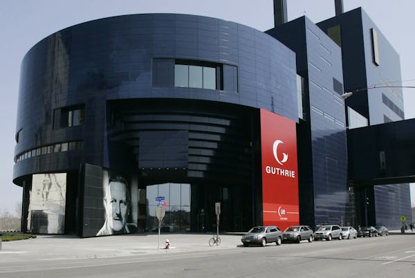 ** FILE ** A photo of Sir Tyrone Guthrie, lower left, graces the front of the Guthrie Theater, in this April 20, 2007 file photo in Minneapolis. Frenc