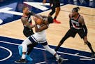 Portland Trail Blazers guard Damian Lillard, left, battles for control of the ball with Minnesota Timberwolves guard Anthony Edwards as Portland Trail