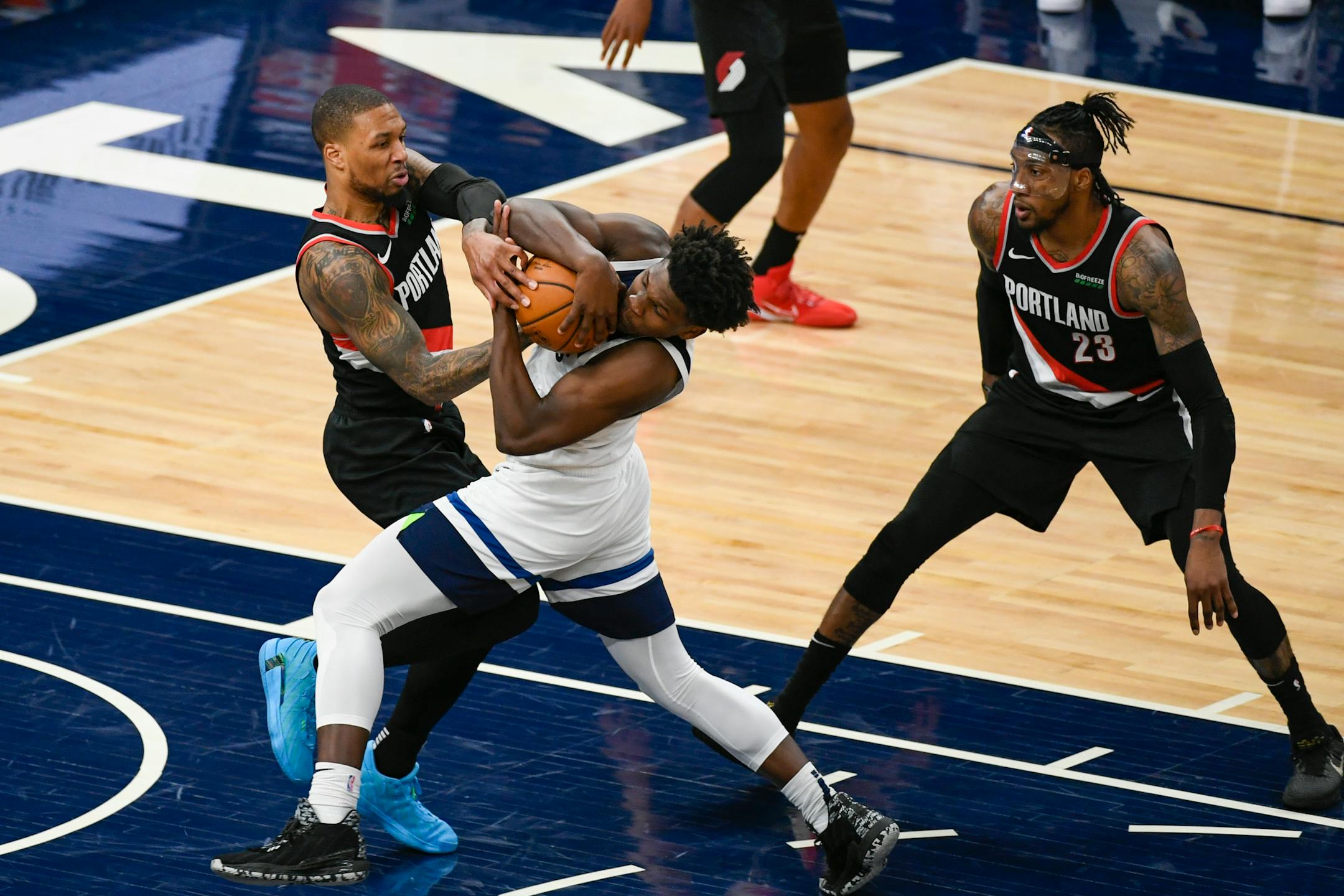 Portland Trail Blazers guard Damian Lillard, left, battles for control of the ball with Minnesota Timberwolves guard Anthony Edwards as Portland Trail Blazers forward Robert Covington looks on during the second half of an NBA basketball game Sunday, March 14, 2021, in Minneapolis. Timberwolves won 114-112. (AP Photo/Craig Lassig)