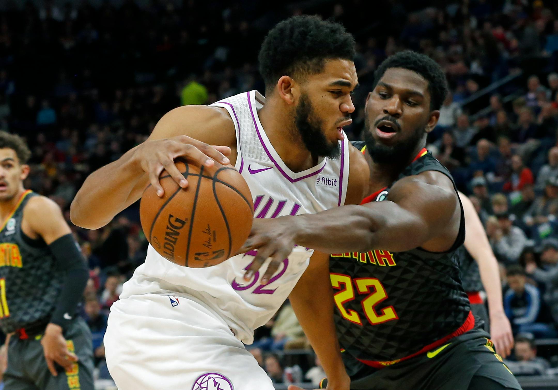 Atlanta's Alex Poythress, right, tries to reach the ball as the Timberwolves' Karl-Anthony Towns drives to the basket in the first half.
