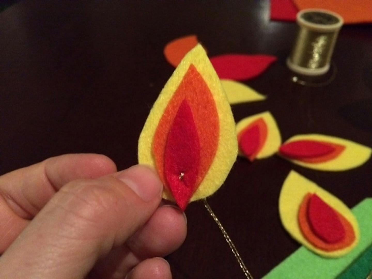 Part of step-by-step instructions for crafting a felt dumpster fire holiday ornament.