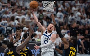 Timberwolves guard Donte DiVincenzo (0) scored over Warriors Draymond Green and Jonathan Kuminga on Tuesday at Target Center.