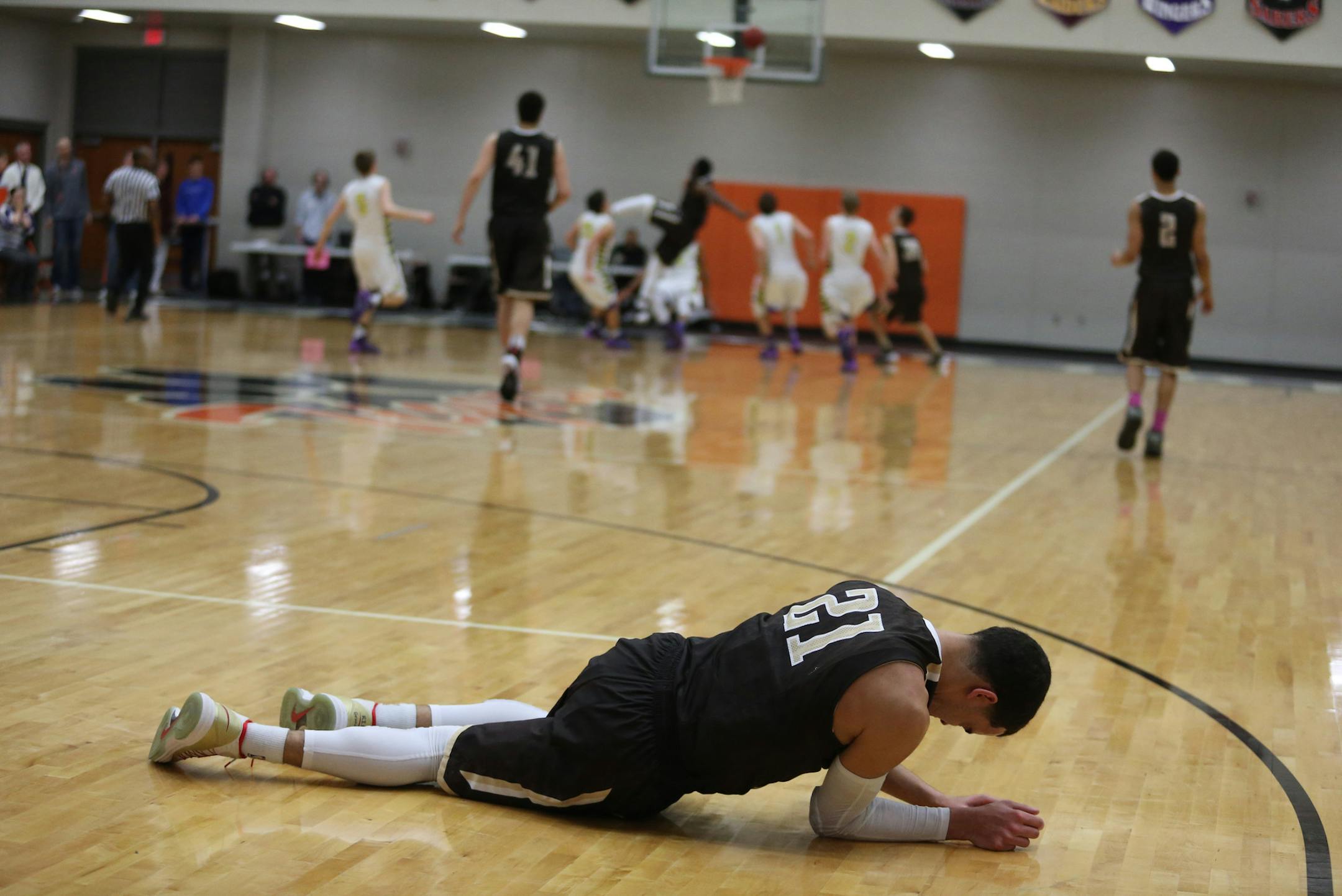 Apple Valley's Tyus Jones laid on the court after being injured as Cretin Durham went ahead by 10 with less than a minute to play. ] (KYNDELL HARKNESS/STAR TRIBUNE) kyndell.harkness@startribune.com During the sectional finals at Farmington High School, in Farmington Thursday, March 6, 2014. Cretin Durham won 89-77 over Apple Valley.