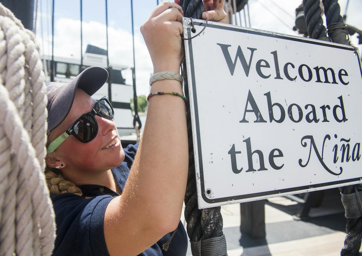 Crystal Platt, crew member on the Nina, hung a welcome sign on the ship at the city of Hudson's docks on Thursday. ] Isaac Hale &#xef; isaac.hale@startribune.com The Pinta and the Nina, replicas of Christopher Columbus' ships, sailed into the city docks of Hudson, WI, on Thursday, July 7, 2016.