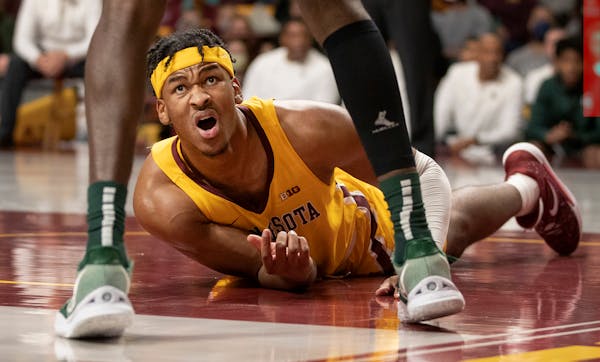 Eric Curry (1) of Minnesota looks up after falling in the first half Wednesday, Dec. 8, 2021 at Williams Arena in Minneapolis, Minn. ] CARLOS GONZALEZ