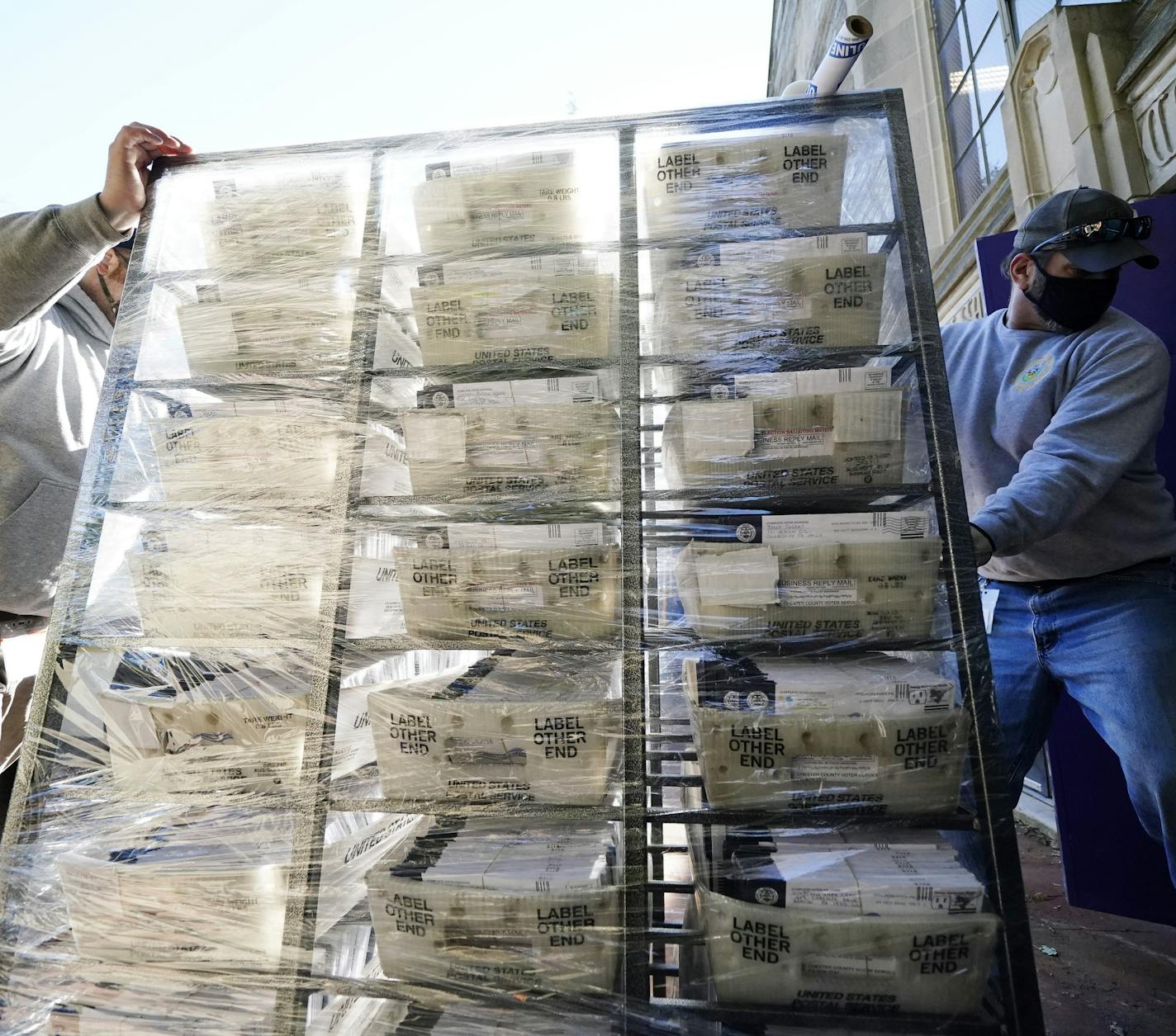 Chester County, Pa. workers transport mail-in and absentee ballots to be processed at West Chester University, Wednesday, Nov. 4, 2020, in West Chester. The fate of the United States presidency hung in the balance Wednesday morning, as President Donald Trump and Democratic challenger Joe Biden battled for three familiar battleground states, Wisconsin, Michigan and Pennsylvania, that could prove crucial in determining who wins the White House. (AP Photo/Matt Slocum)