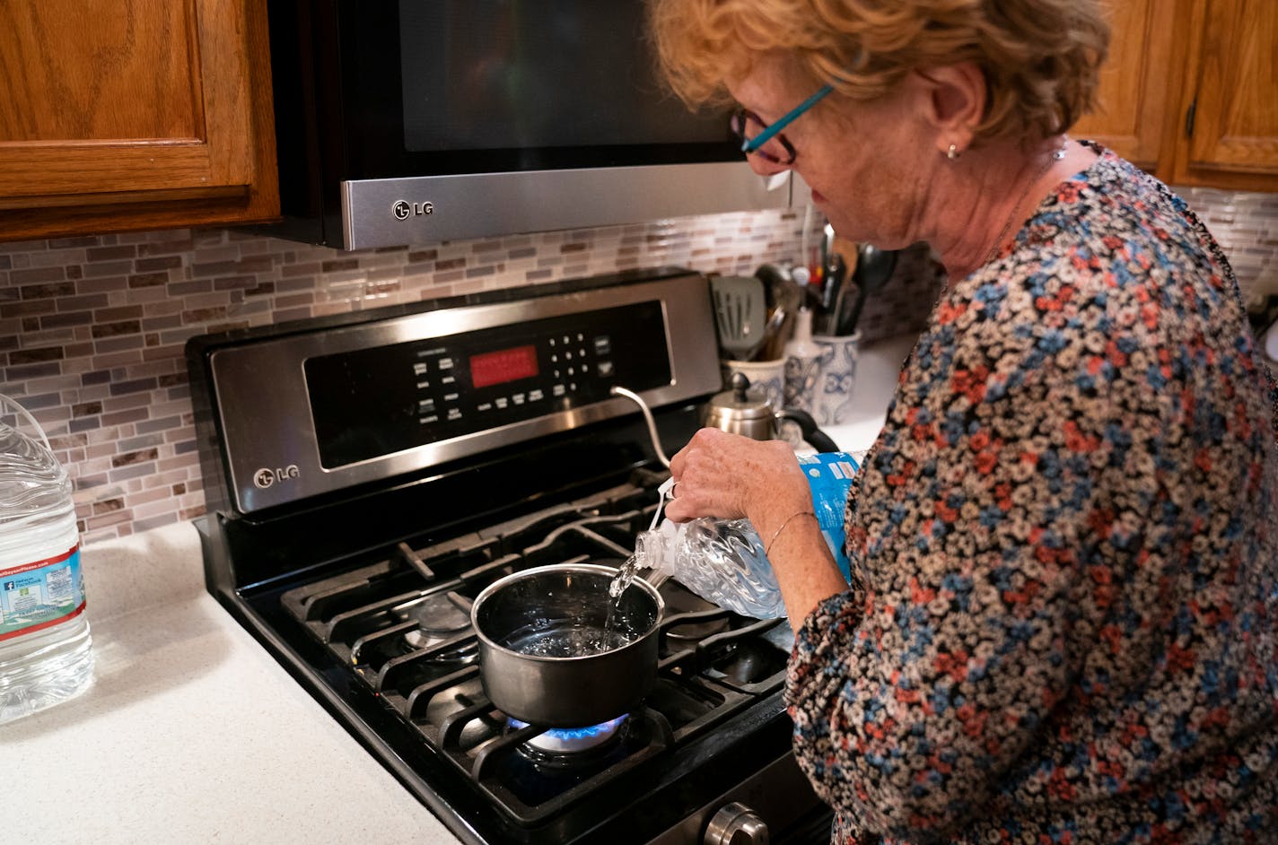 Monika Dipert filled her pot with bottled water to boil rice in her home in Andover, Minn., on Thursday, September 23, 2021. Dipert was shocked to learn two months ago that her well water was heavily contaminated with the carcinogen dioxide likely the result of a closed landfill near her Andover home. "I can't sleep. I lay in bed and think what should I look up next," said Dipert who has become overwhelmed with what she can do to protect her health and get help from the city fixing the problem. The city has been bringing bottled water to homes in the neighborhood with high contamination.