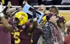 Minnesota head coach Tracy Claeys is doused with a sports drink after winning the Quick Lane Bowl NCAA college football game against Central Michigan,