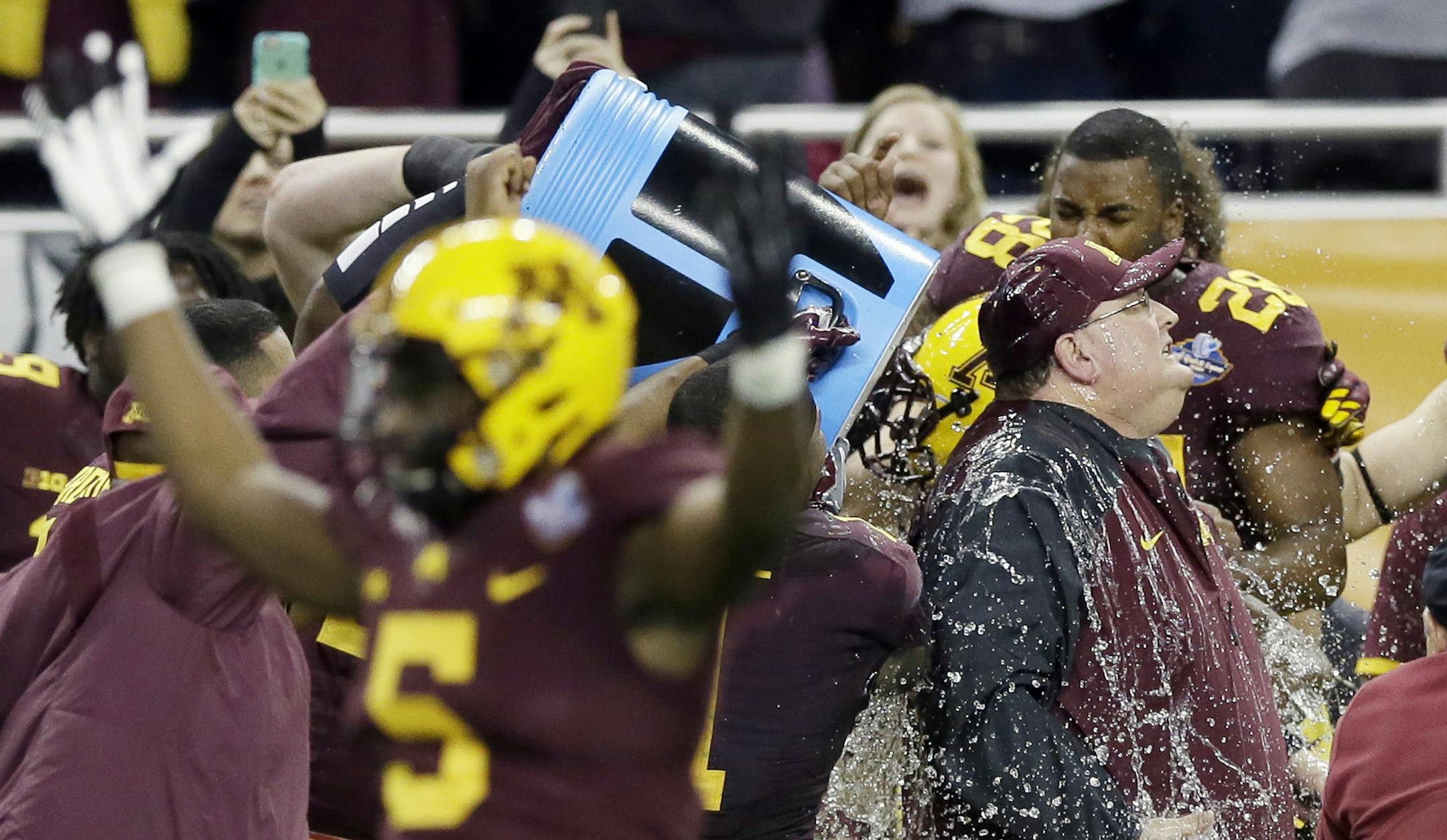 Minnesota head coach Tracy Claeys is doused with a sports drink after winning the Quick Lane Bowl NCAA college football game against Central Michigan, Monday, Dec. 28, 2015, in Detroit. Minnesota won the game 21-14. (AP Photo/Carlos Osorio) ORG XMIT: MIN2015122917193948