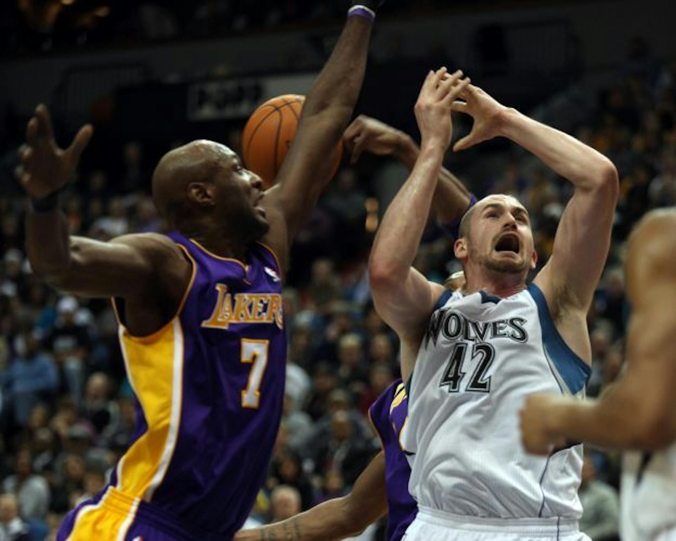 The Minnesota Timberwolves' Kevin Love (42) has the ball knocked out of his hands by the Los Angeles Lakers' Lamar Odom (7) during first-half NBA action at the Target Center in Minneapolis, Minnesota, on Friday, November 19, 2010.