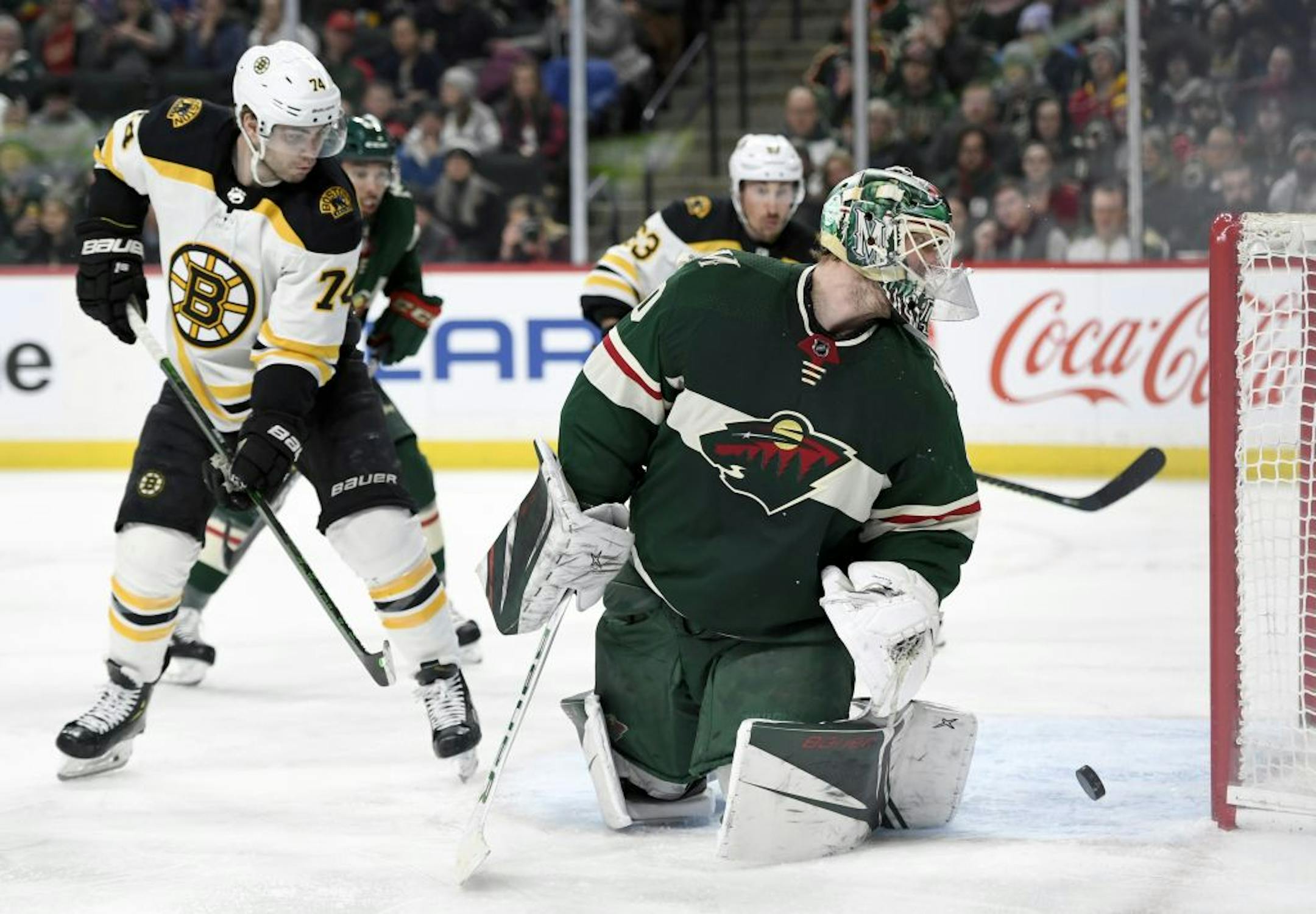 Minnesota Wild goaltender Devan Dubnyk (40) and Boston Bruins left wing Jake DeBrusk (74) watch as the shot by Boston Bruins' Torey Krug, not pictured, goes into the net during the second period of an NHL hockey game Saturday, Feb. 1, 2020, in St. Paul, Minn.