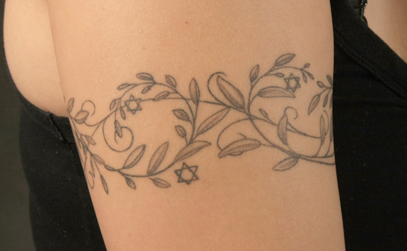 Melanie Teichner, close-up of the decorative tattoo on her arm, olive vines and the Star of David