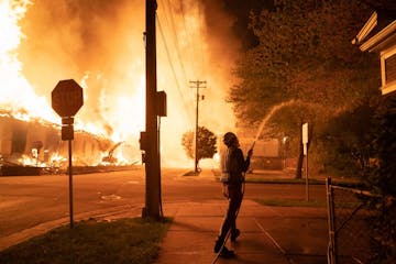 Minneapolis residents used garden hoses and buckets to save homes May 27 after rioters set fire to a housing complex under construction near the Third