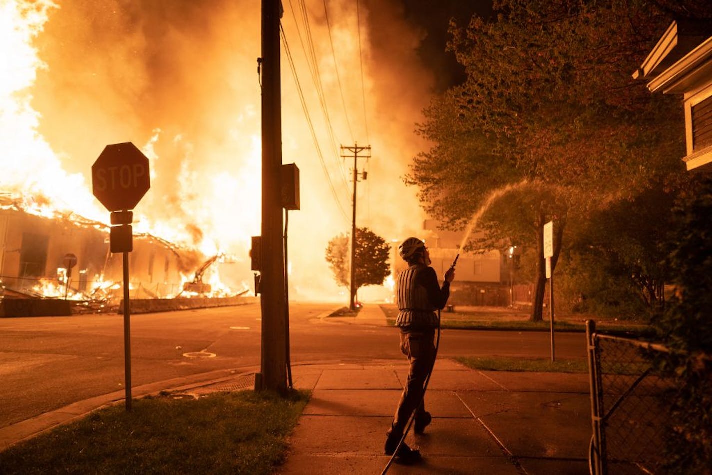 Minneapolis residents used garden hoses and buckets to save homes May 27 after rioters set fire to a housing complex under construction near the Third Precinct station.