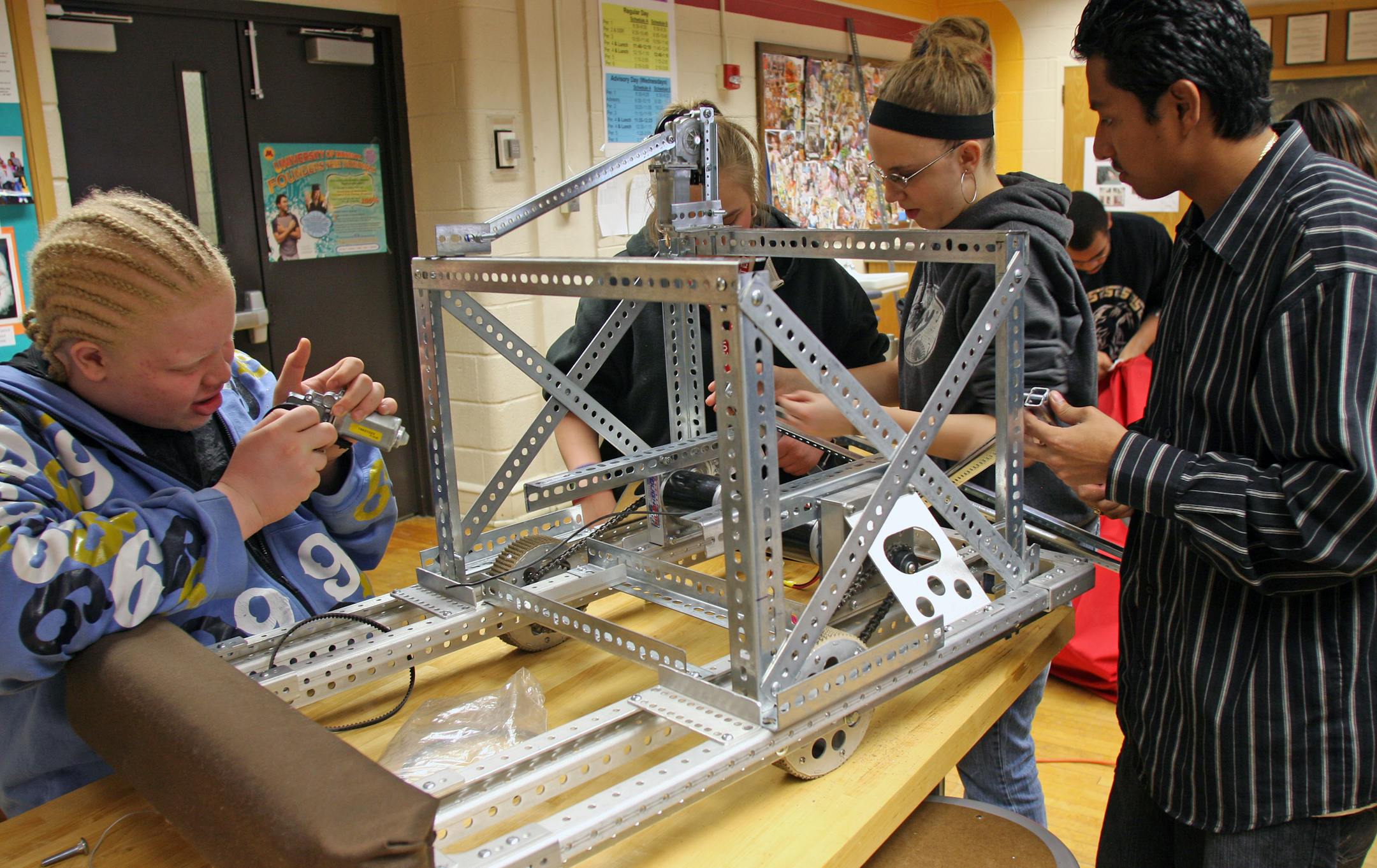 The object of the FIRST Robotics competition: Build a robot that can push a ball along, among other tasks. Working to do just that are, from left, Dray Fairchild, Amanda Carter, Mindy Blom and Cesar Avalos of Patrick Henry High School in Minneapolis. Their team is one of 54 taking part in the Minnesota regional this month.