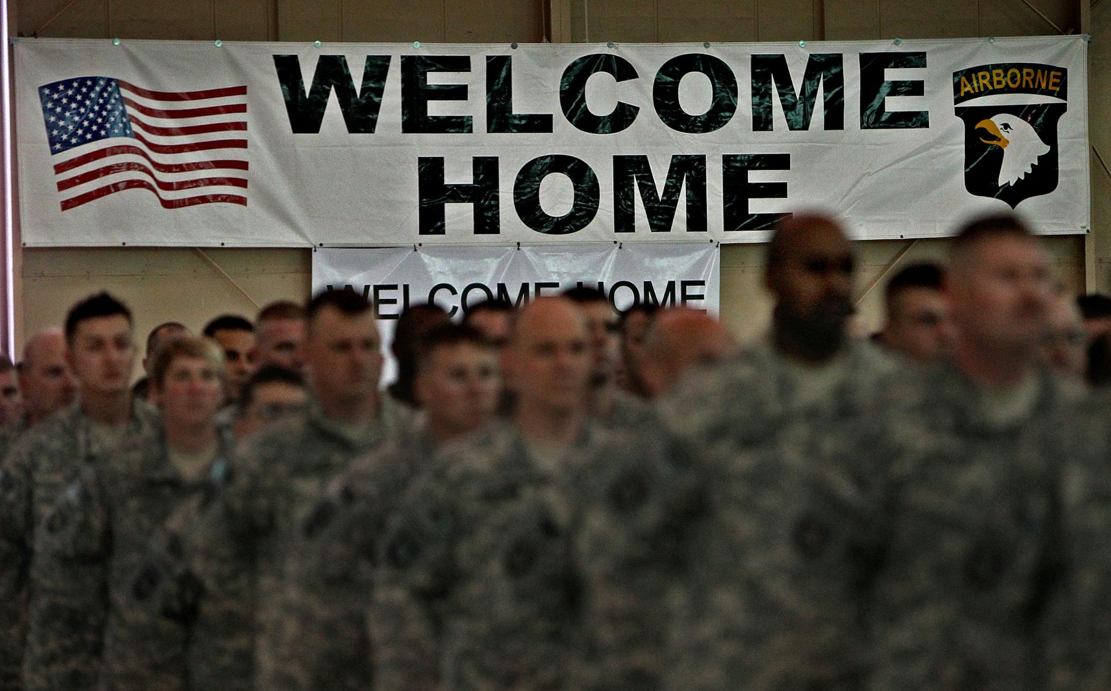 Soldiers stood together during a welcome home ceremony in a hanger. After several dignitaries spoke, troops were reunited with their families.