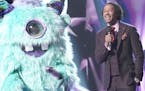 Nick Cannon, right, and the unidentified singer the Monster on Fox's new variety show, "The Masked Singer."