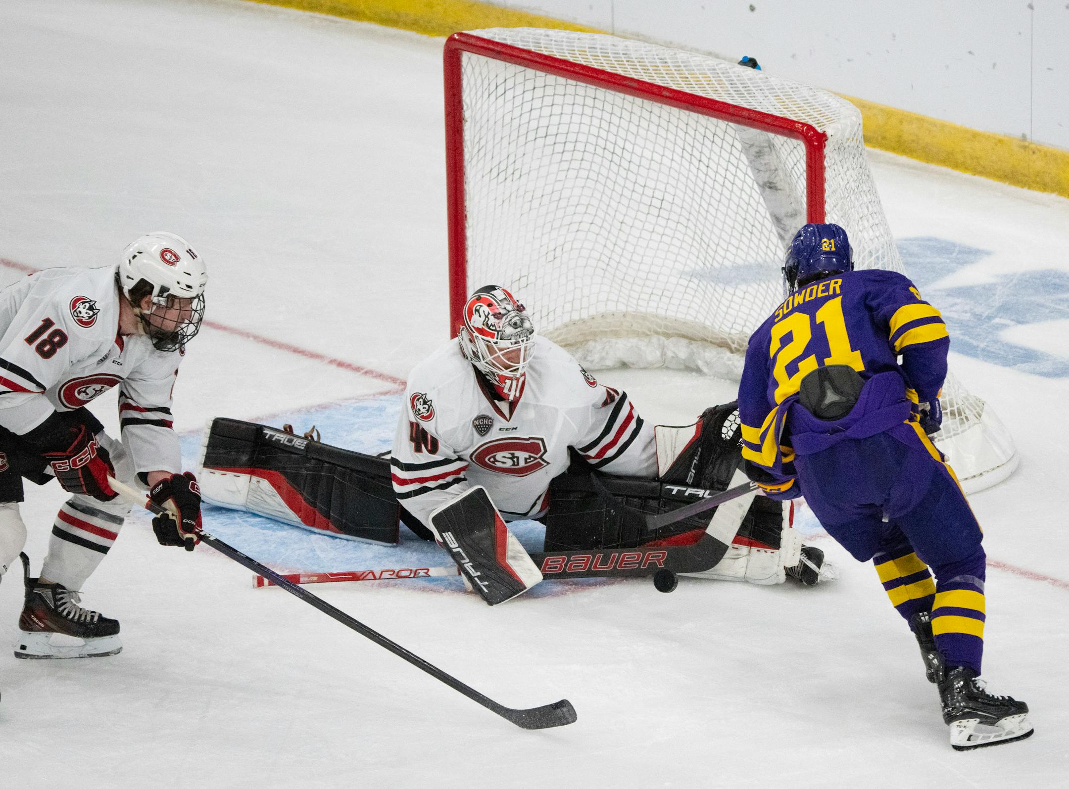 St. Cloud State Huskies goaltender Jaxon Castor (40) denied a shot by Minnesota State Mavericks forward Lucas Sowder (21) in the first period while St. Cloud State Huskies defenseman Brendan Bushy (18) moved in for the loose puck.