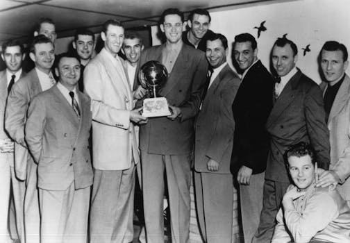 Sid and the champs: The 1950 NBA champion Minneapolis Lakers featured Sid Hartman, far left; star players Jim Pollard and George Mikan, both holding trophy; and Bud Grant, behind Pollard.