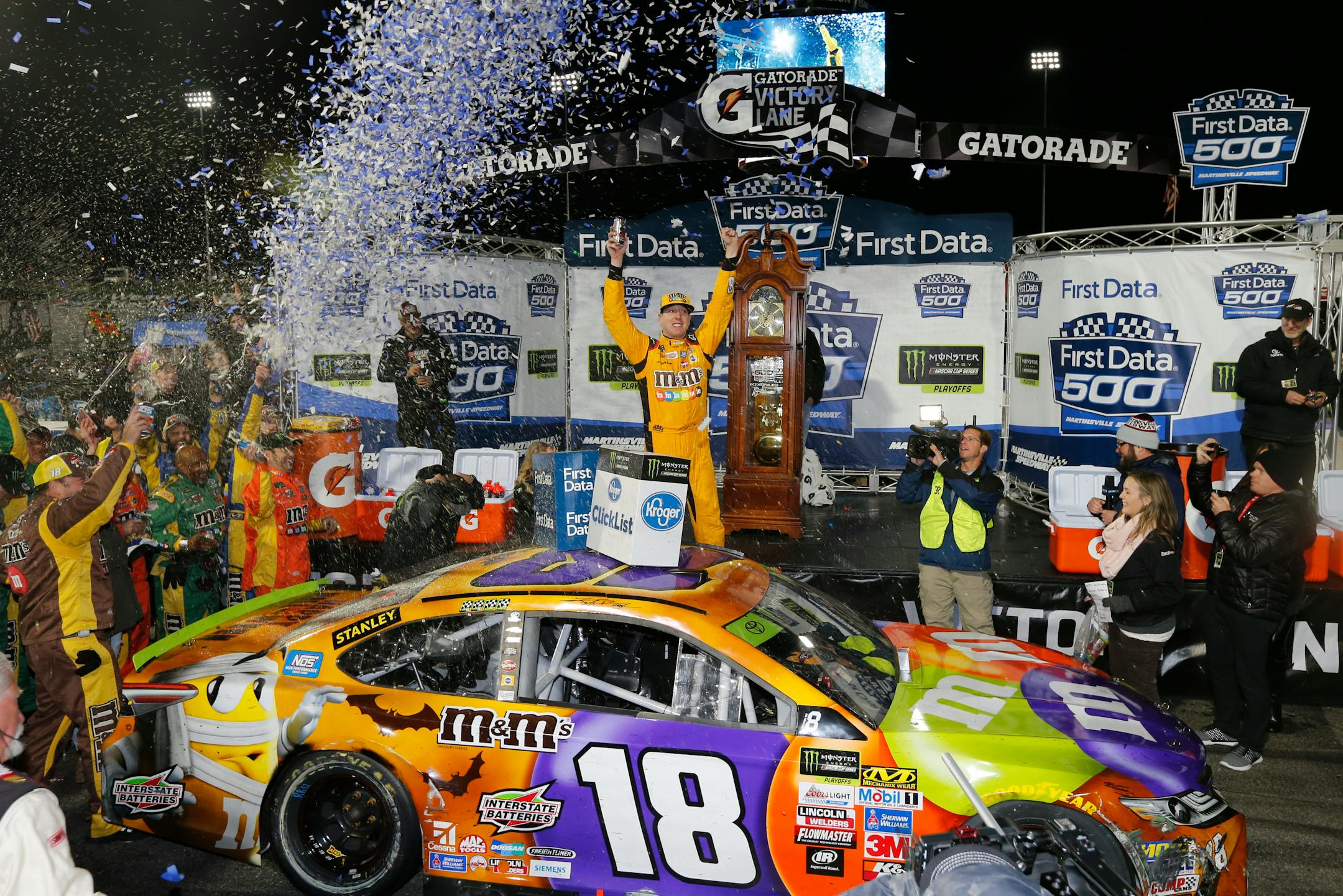 Kyle Busch, center, celebrated under the lights after winning the NASCAR Cup series auto race at Martinsville Speedway in Martinsville, Va., on Sunday.