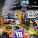 Kyle Busch, center, celebrated under the lights after winning the NASCAR Cup series auto race at Martinsville Speedway in Martinsville, Va., on Sunday