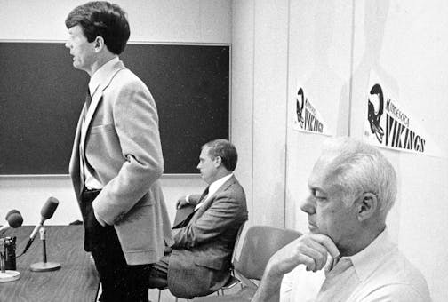 Minnesota Vikings coach Bud Grant, right, seems to have other things on his mind than new Coach Les Steckel's remarks to a press conference at the team's headquarters in Eden Prairie, Minn., Jan. 31, 1984. Grant retired after 27 years in coaching in order to pursue his favorite outdoor activities. Steckel, 37, will be the youngest coach in the NFL. In background is Vikings general manager Mike Lynn. (AP Photo/Larry Salzman)