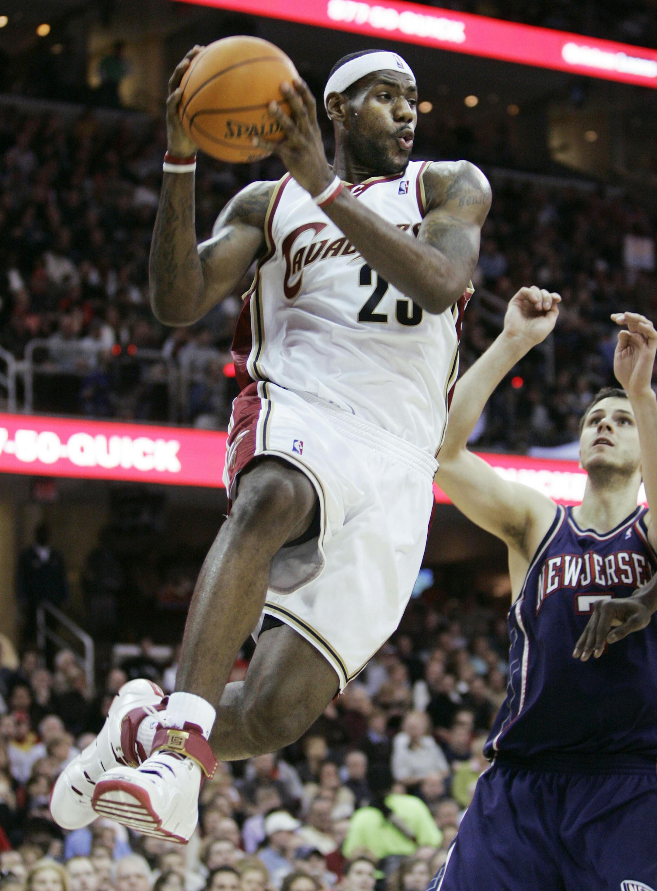 Cleveland Cavaliers' LeBron James (23) looks for a teammate to pass to as New Jersey Nets' Bostjan Nachbar (7), from Slovenia, watches in the second quarter, in an NBA basketball game, Saturday, Jan. 6, 2007, in Cleveland. (AP Photo/Tony Dejak) ORG XMIT: OTKTD103