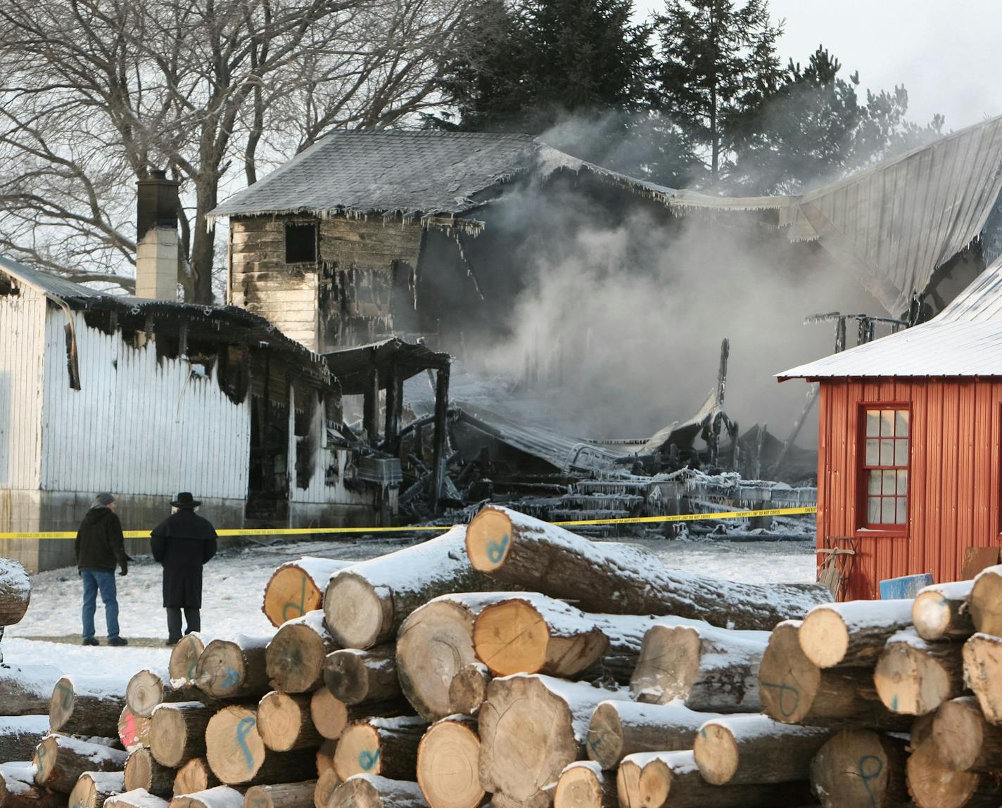 An Amish man talks to a neighbor outside an Amish home that burned north of Canton, Minn., Monday morning Jan.11, 2016. Authorities say two people are missing and two others have been injured in the fire. (Ken Klotzbach/The Rochester Post-Bulletin via AP) MANDATORY CREDIT