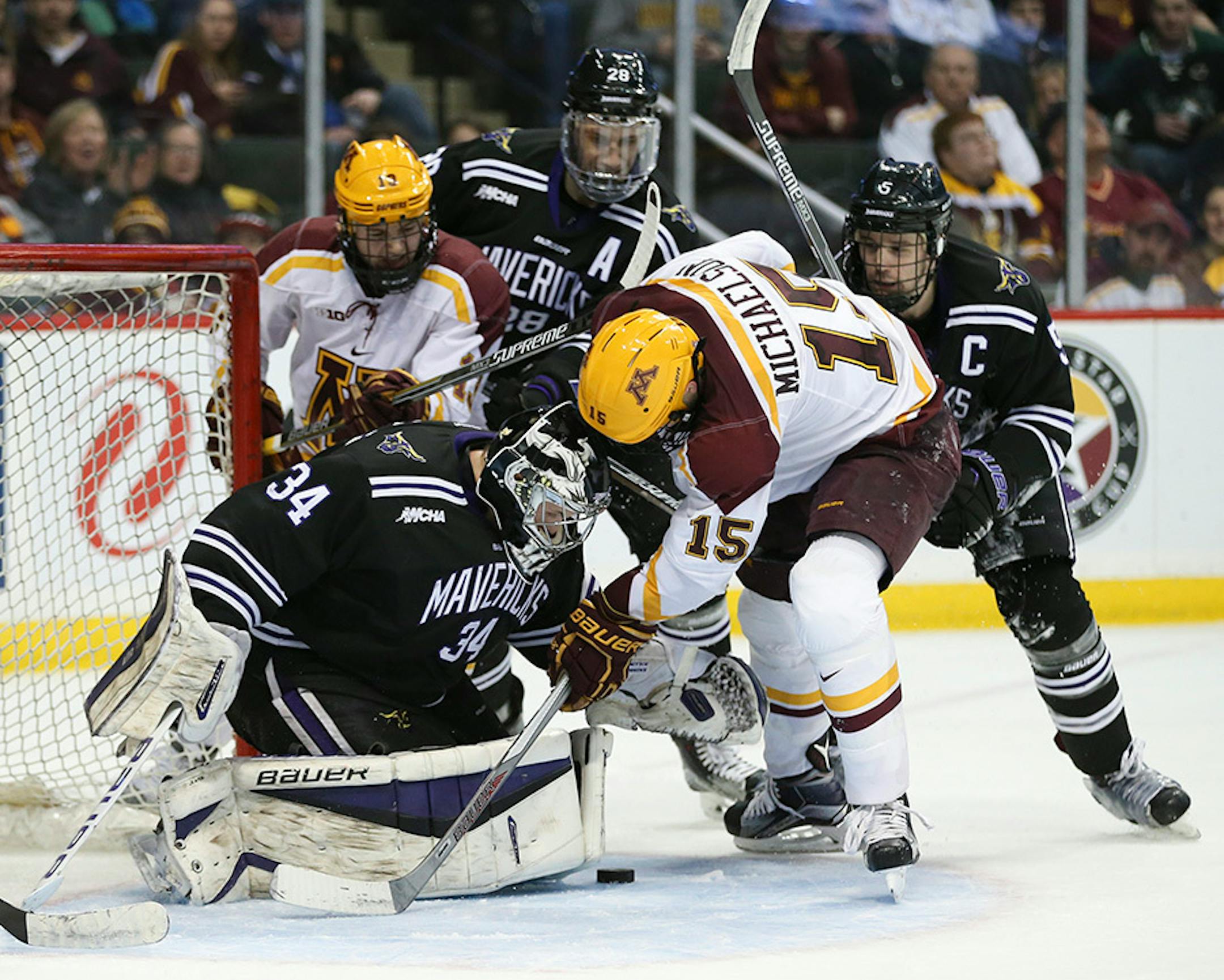 Gophers forward A.J. Michaelson (15) tried to get to the loose puck in front of Mavericks goalie Cole Huggins (34) before he could in the second period Sunday afternoon. Mavericks win 3-2