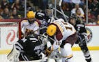 Gophers forward A.J. Michaelson (15) tried to get to the loose puck in front of Mavericks goalie Cole Huggins (34) before he could in the second perio
