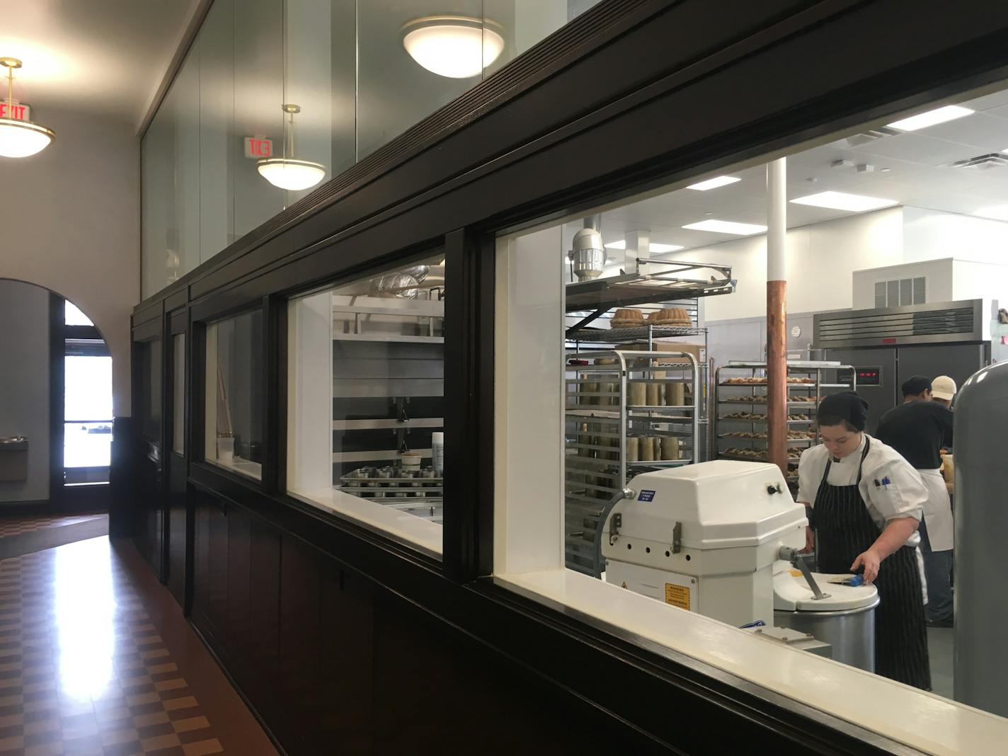 Through viewing windows, customers can watch bakers mixing dough, topping croissants with almonds and making the bakeries' beloved breads.