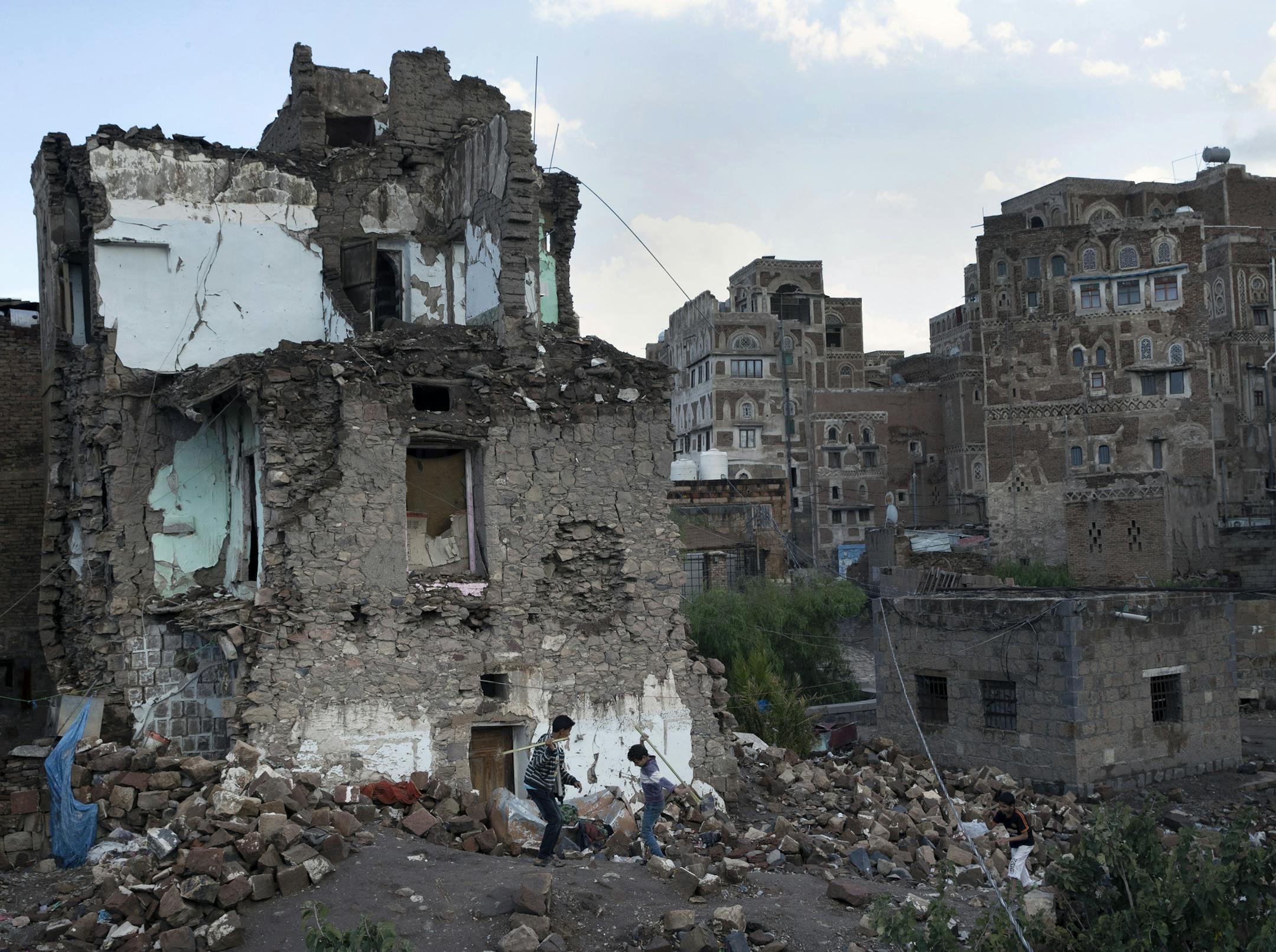 Boys play on Oct. 23, 2018, in the rubble of a home destroyed in an airstrike on the Old City of Sanaa, Yemen. The Saudi-led war in Yemen has pushed millions to the brink of starvation. (Tyler Hicks/The New York Times)