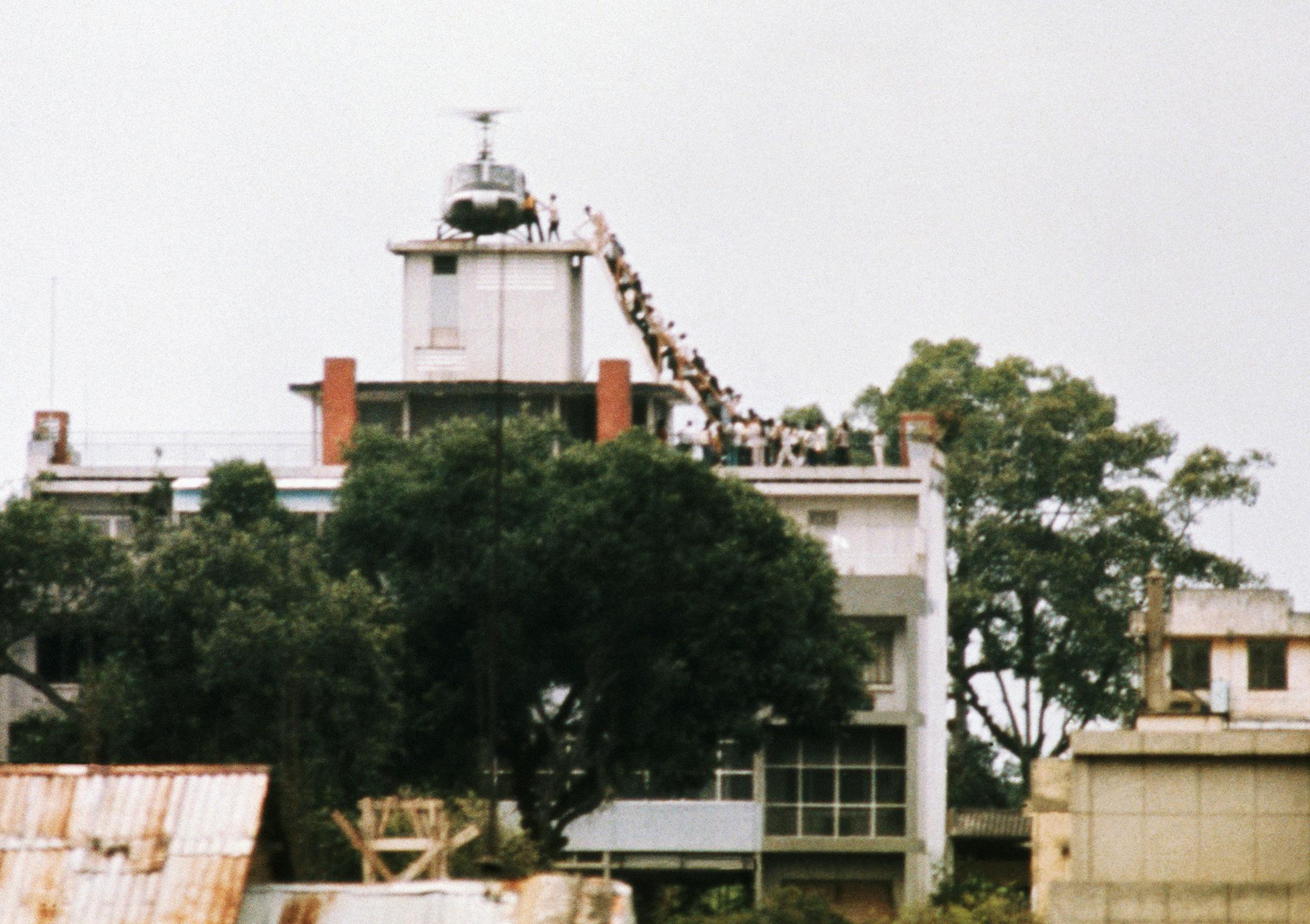 A CIA employee (probably O.B. Harnage) helps Vietnamese evacuees onto an Air America helicopter from the top of 22 Gia Long Street, a half mile from the U.S. Embassy. (Copyright Bettmann/Corbis / AP Images) ORG XMIT: BE001049