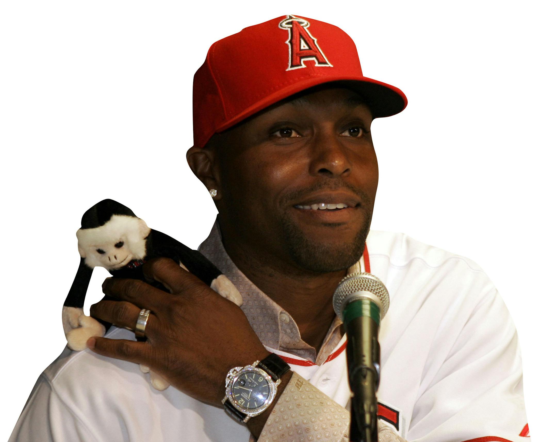 Baseball player Torii Hunter, newly acquired by the Los Angeles Angels, jokes about the rally monkey during a news conference Wednesday, Nov. 28, 2007, in Anaheim, Calif. (AP Photo/Ric Francis) ORG XMIT: CARF103