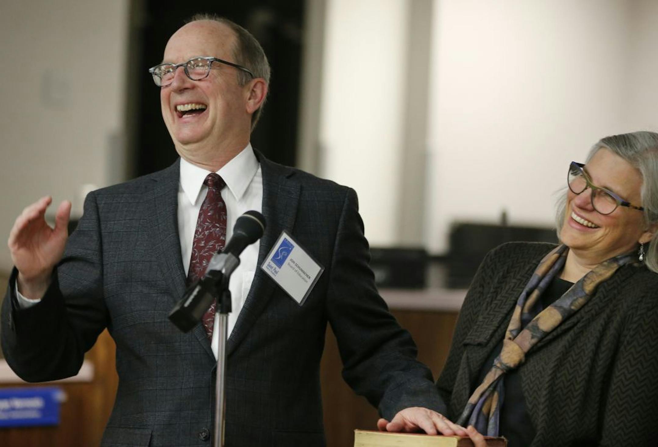Jon Schumacher, a candidate who ran under a Caucus for Change banner critical of district leadership is sworn in as a new St. Paul School Board member with his wife Briggs, next to him.