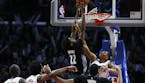 The Los Angeles Clippers' Wesley Johnson reaches through the net to defend the shot of the Minneota Timberwolves' Andrew Wiggins during second-half ac