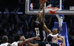 The Los Angeles Clippers' Wesley Johnson reaches through the net to defend the shot of the Minneota Timberwolves' Andrew Wiggins during second-half ac