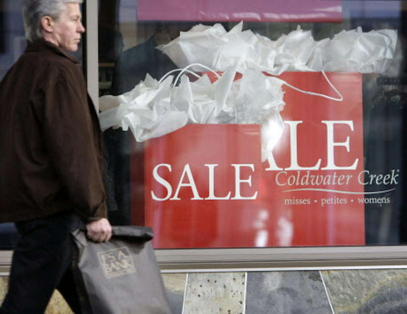 FILE - In this Oct. 6, 2009 file photo, a shopper walks past a Coldwater Creek store in downtown Seattle. The women's clothing retailer has filed for Chapter 11 bankruptcy protection after failing to find a potential buyer or a source of capital to help fund its turnaround efforts. The company said Friday April 11, 2014 that it expects to start sales to liquidate inventory in early May. It plans to hold going out of business sales in the coming months. (AP Photo/Elaine Thompson)