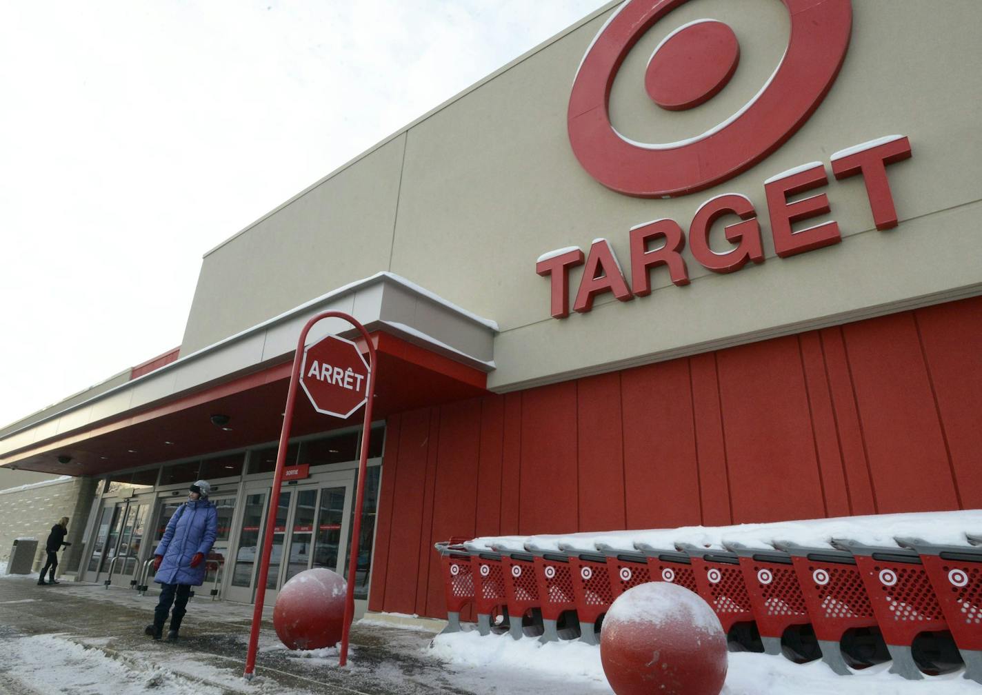 A woman stands outside Target in Saint-Eustache, Quebec, on Thursday, Jan. 15, 2015. Target says it will close its stores in Canada _ a market that it entered only two years ago. Target Corp. Chairman and CEO Brian Cornell said Thursday that the company was unable to find a realistic scenario in which the 133-store Target Canada would become profitable before at least 2021. (AP Photo/The Canadian Press, Ryan Remiorz)